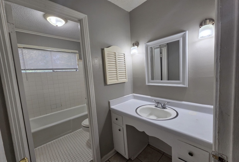 Full bath with light tile patterned floors, vanity, a textured ceiling, and bathing tub / shower combination