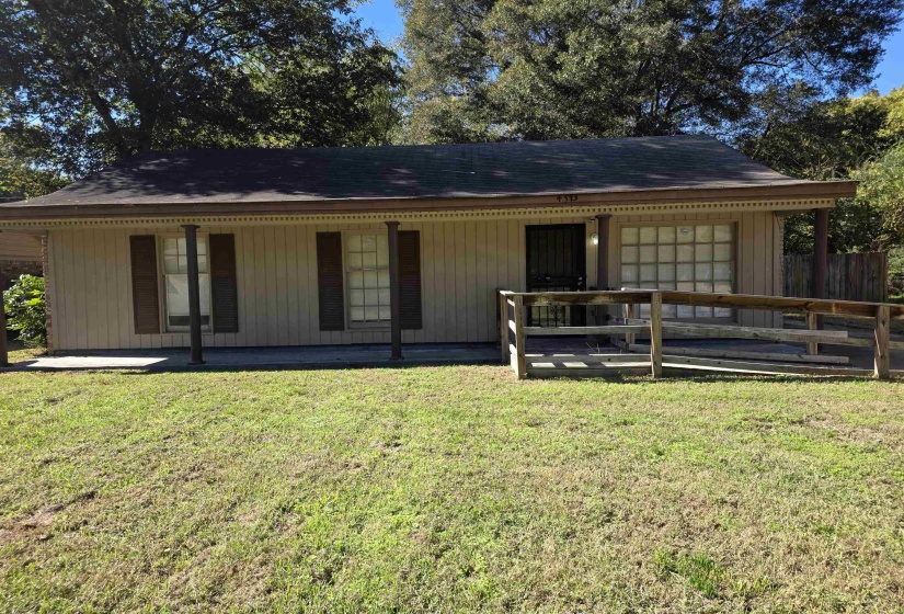 Back of house featuring a porch, a yard, and a garage