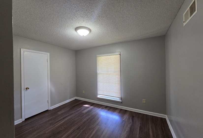 Spare room with dark wood-type flooring and a textured ceiling