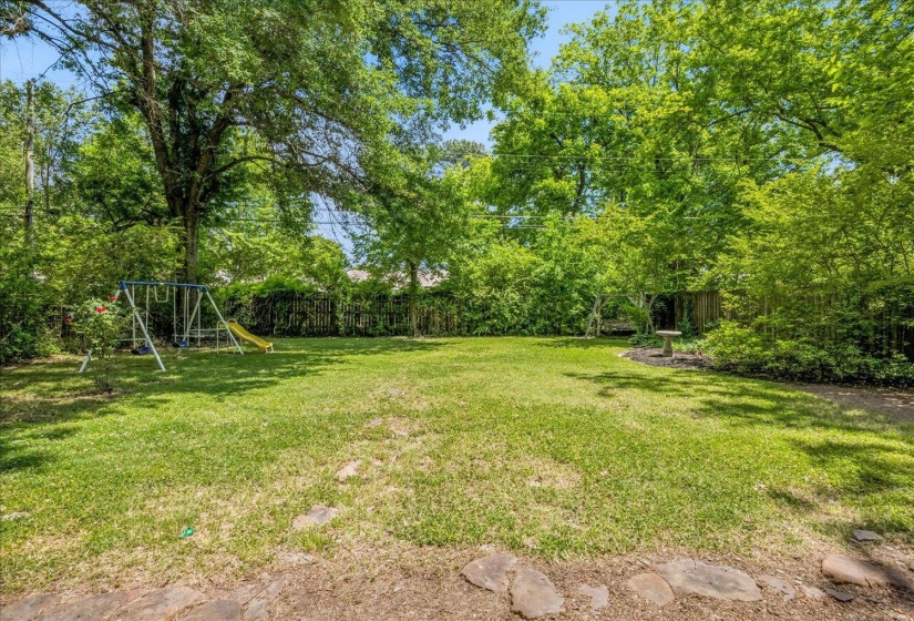 Expansive backyard featuring mature trees, and perimeter fencing.