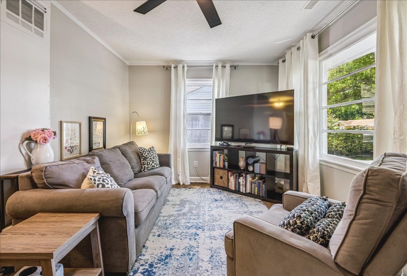 Living area featuring hardwood floors and lots of windows for plenty of natural light.