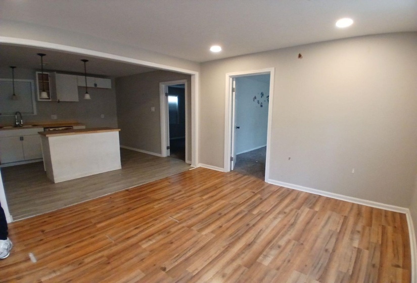 Open-concept living area featuring wood-finish flooring, recessed lighting, and neutral wall tones