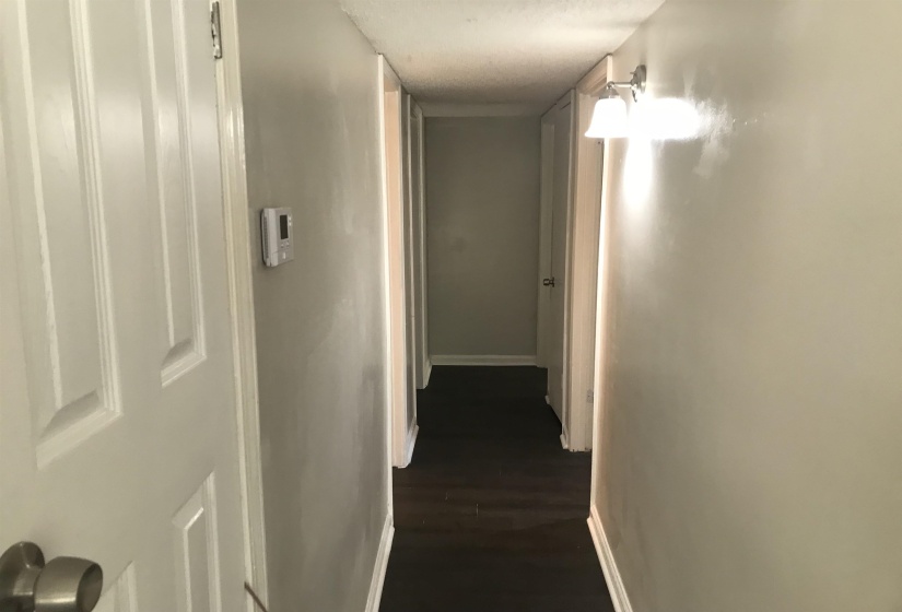 Hall with baseboards and dark wood-style floors