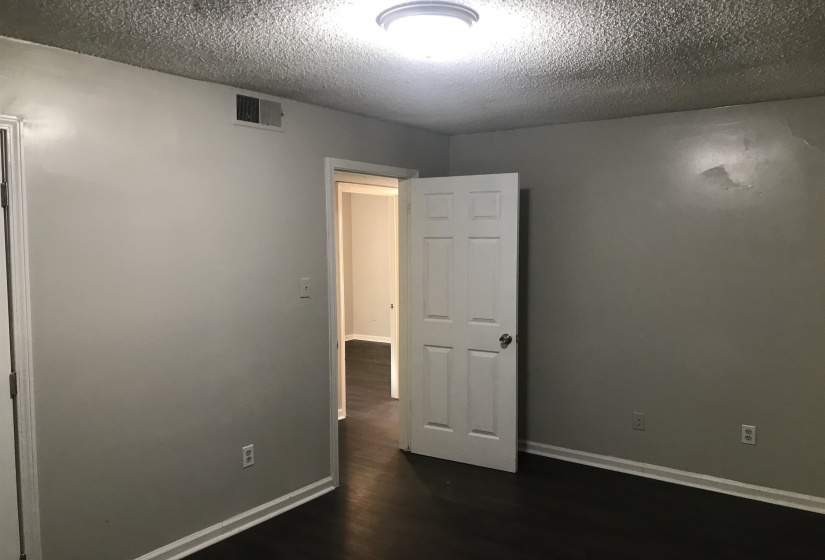 Spare room with dark wood-style floors and a textured ceiling