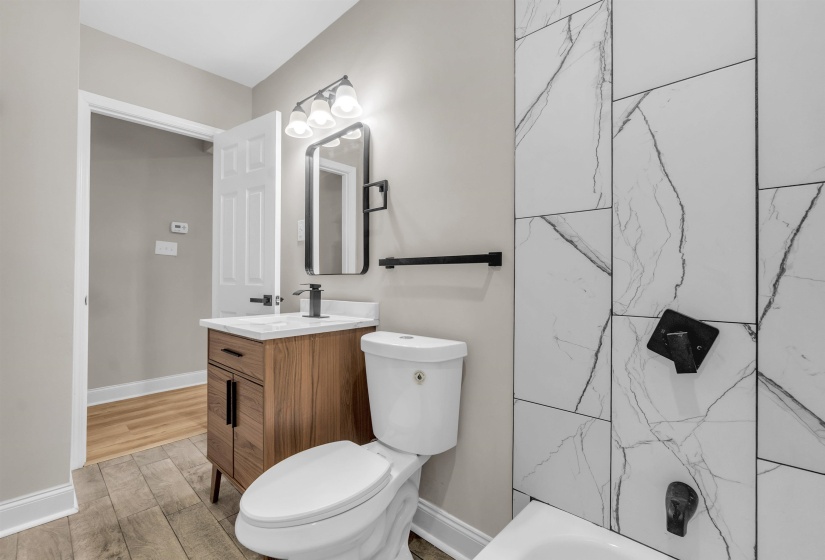 Bathroom featuring vanity, light wood finished floors, and washtub / shower combination