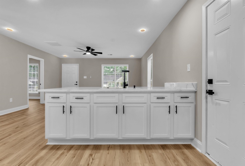 Kitchen with a peninsula, white cabinetry, light wood-style floors, ceiling fan, and recessed lighting