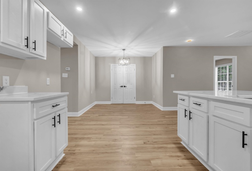 Unfurnished dining area with light wood-style flooring and suspended lighting