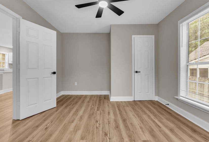 Unfurnished bedroom with light wood-style flooring, a ceiling fan, and vaulted ceiling