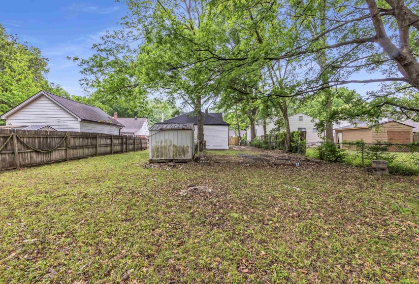 Fenced backyard with an outbuilding and a detached garage