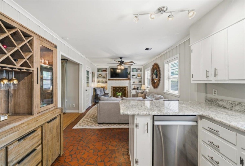 Kitchen counter with light-toned stone surface and white cabinetry