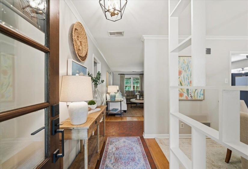 Foyer featuring a wood-panel entry door with glass inserts, recessed lighting, and a decorative chandelier