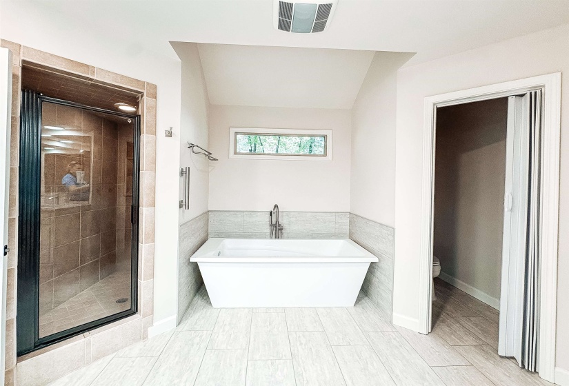 Spacious bathroom featuring light wood-finish flooring