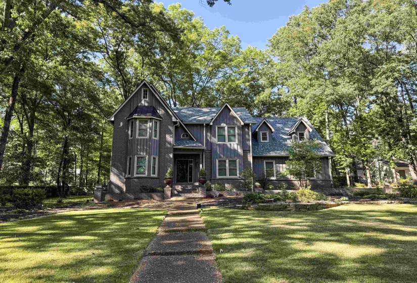 Gable-front home featuring board and batten siding and a stone foundation