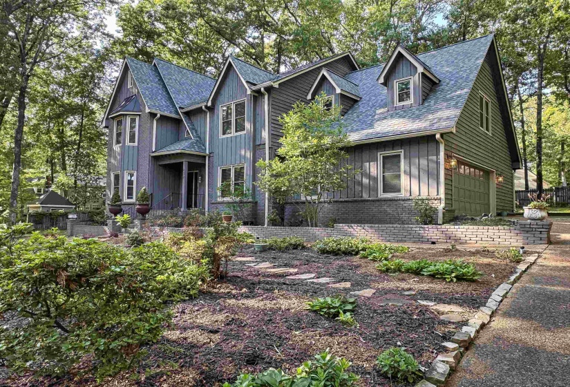 Multi-level exterior with dormer windows, featuring a prominent front entrance and an attached garage