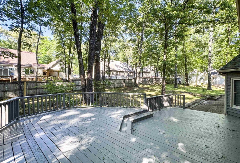 Expansive wooden deck featuring perimeter railing, integrated steps, and a spacious outdoor area