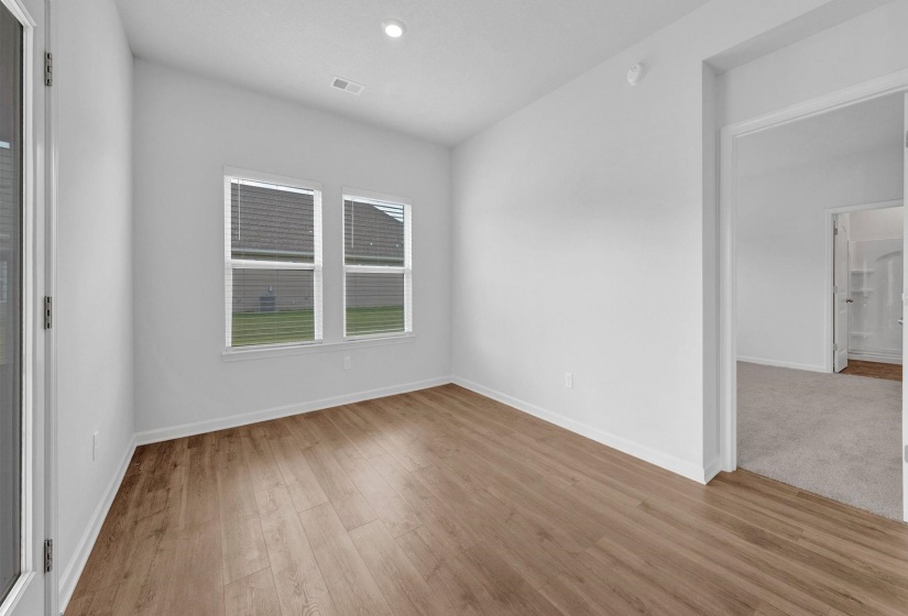 Bright interior room featuring wood-finish flooring and white baseboards