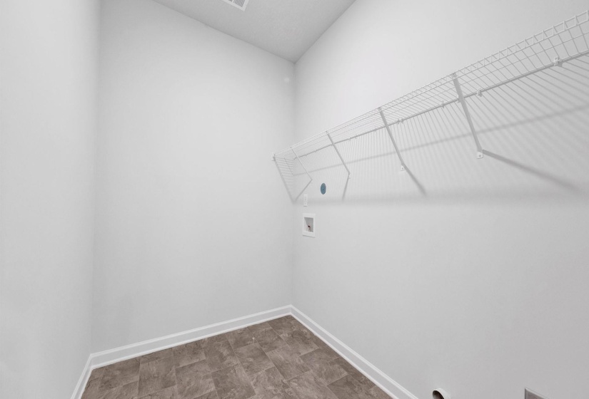 Laundry area featuring wire shelving, white walls, and a patterned flooring