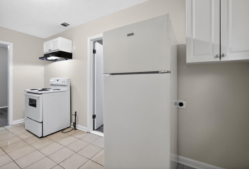Kitchen featuring tile flooring, white cabinetry, a white electric range, and a white refrigerator