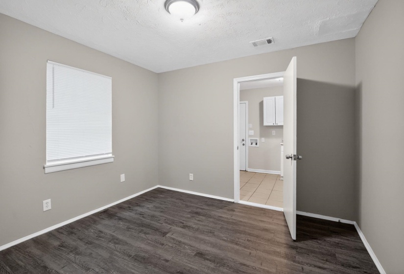 Room featuring wood-finish flooring, neutral wall paint, and white trim