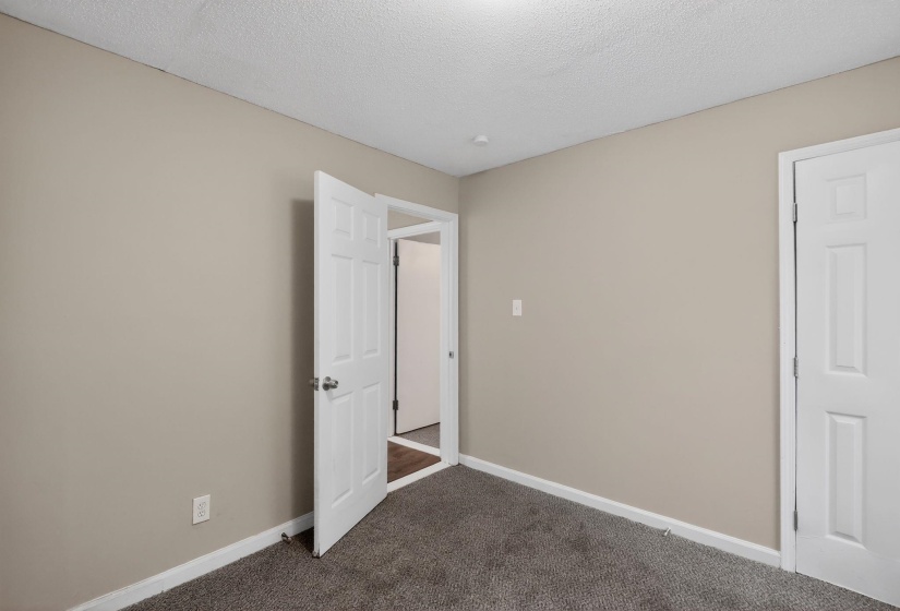 Neutral tone walls with white trim and grey carpet