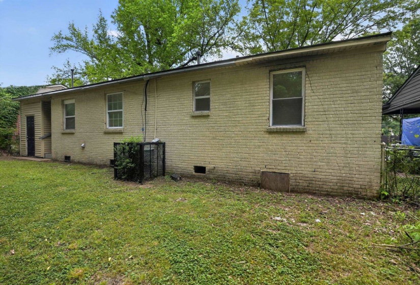 Light brick exterior with multiple windows and an exterior access door