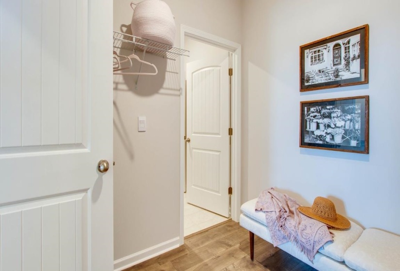 Hallway featuring wood-finish flooring, light neutral wall paint, and white paneled doors