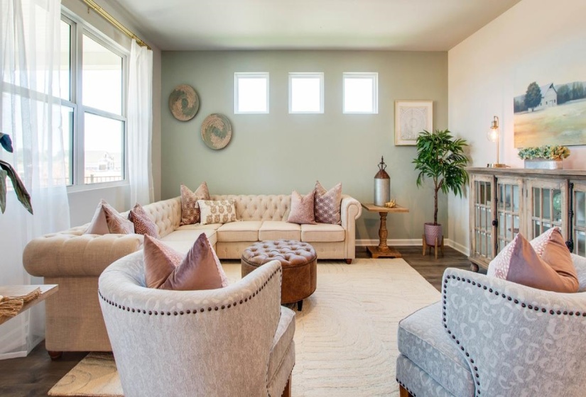 Spacious living area featuring large windows, wood-finish flooring, recessed lighting, and light-toned walls