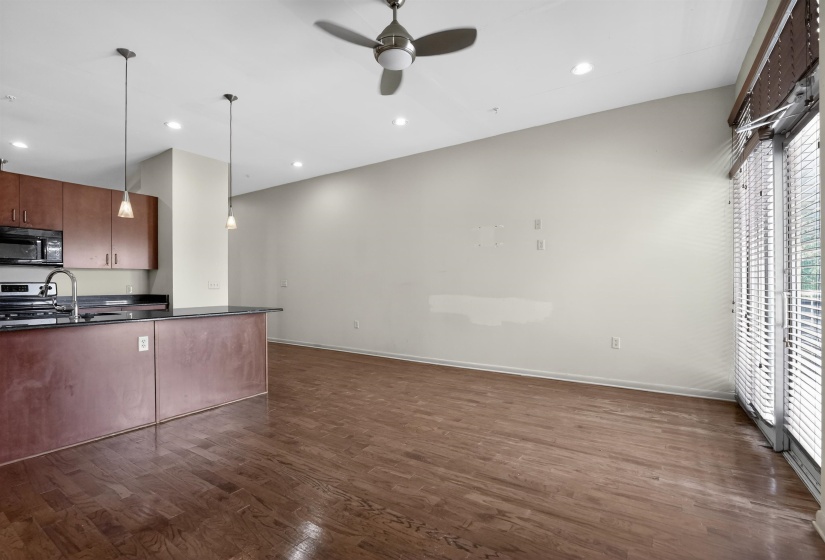Open-concept living space featuring wood-finish flooring, recessed lighting, and a ceiling fan