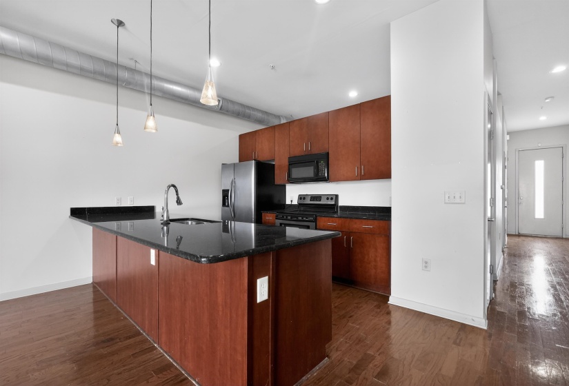 Kitchen featuring a large island with dark stone countertop and integrated sink