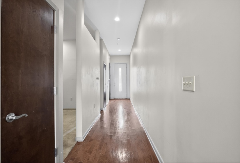 Hallway with wood-finish flooring and recessed lighting