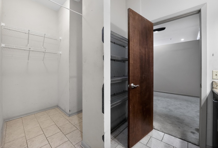 Utility closet with tiled flooring and wire shelving