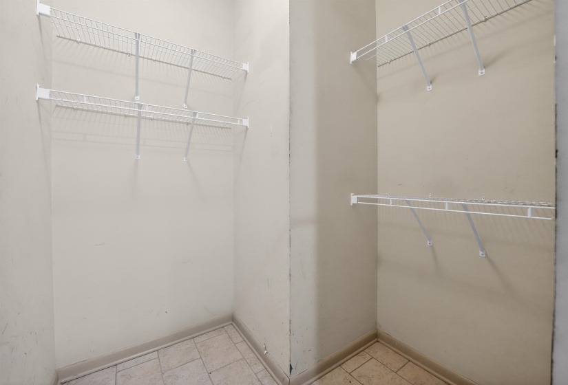 Storage area featuring wire shelving units and light-toned floor tile