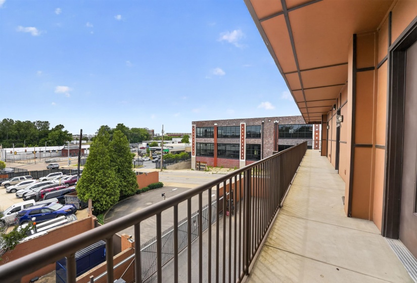 Exterior walkway featuring a metal railing and a concrete surface