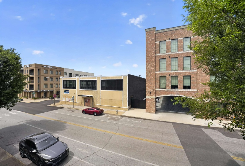 Three-story brick building with prominent arched entryway and large, multi-pane windows