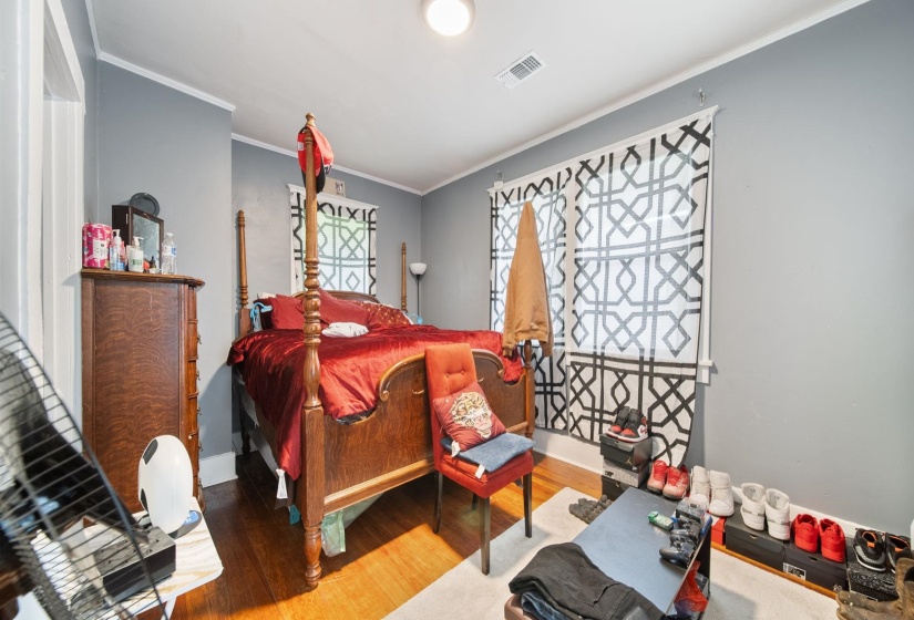 Wood-finish flooring throughout, multiple windows with white trim, gray painted walls, and white ceiling and baseboard molding