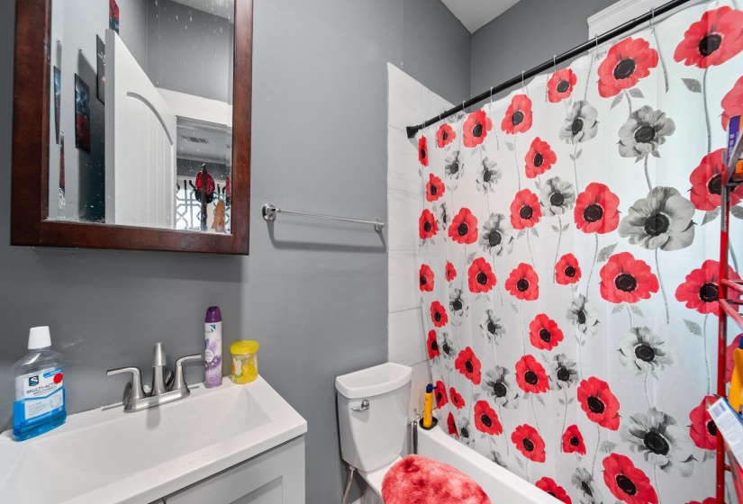 Bathroom featuring a white bathtub, toilet, and vanity with an integrated sink