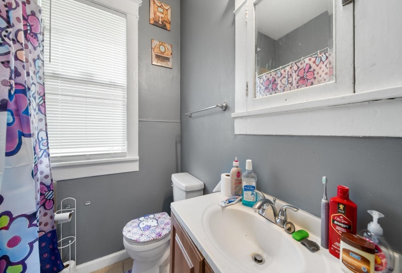 Bathroom with a single vanity, integrated sink, and white-painted wood-frame medicine cabinet
