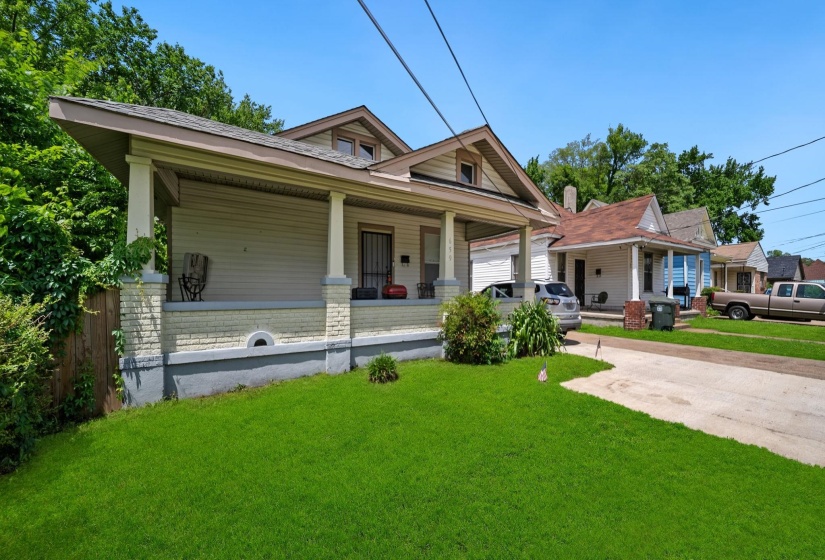 Traditional-style residence featuring a prominent covered front porch with substantial columns, a light-colored brick foundation, and a pitched roofline
