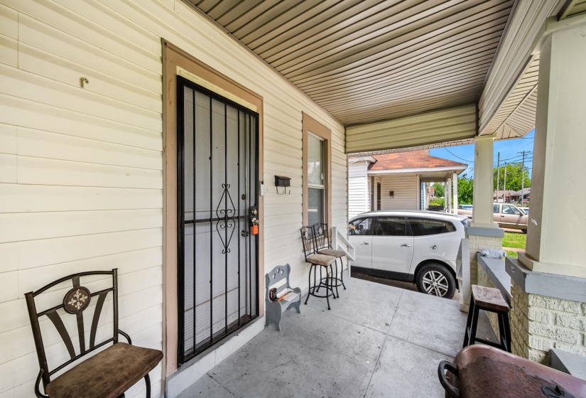 Covered front porch with concrete flooring and white vinyl siding