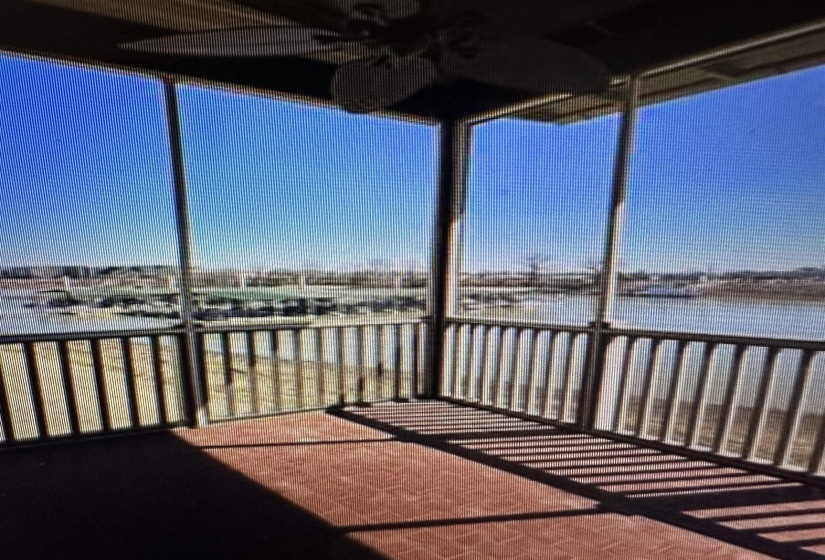 Screened-in porch featuring brick-patterned flooring and a ceiling fan