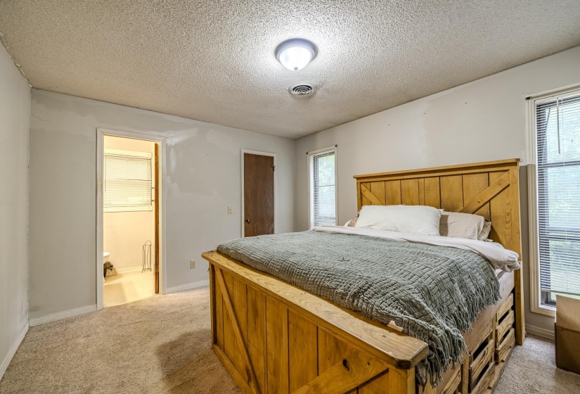 Carpeted room with light-colored walls and a textured ceiling