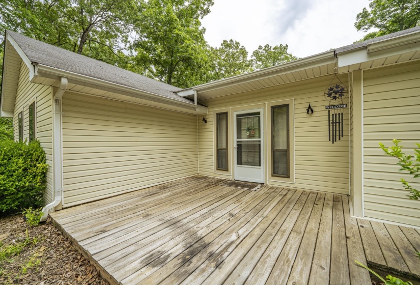 Expansive wood deck with direct entry, featuring durable vinyl siding, a gabled roofline, and integrated gutters