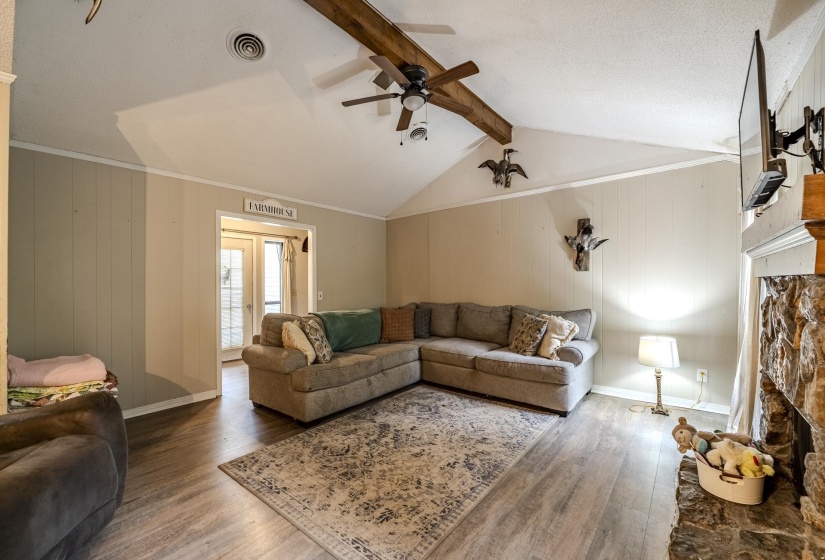 Vaulted ceiling with an exposed wood beam and ceiling fan