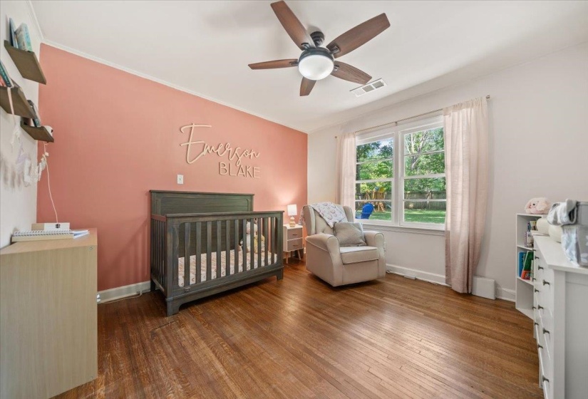 Super cute bedroom with hardwood floors and a ceiling fan.