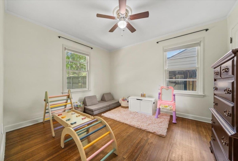 Another beautiful bedroom with hardwood floors and a ceiling fan.