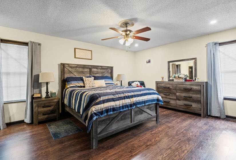 Spacious room featuring wood-finish flooring, a ceiling fan with integrated lighting, and recessed lighting
