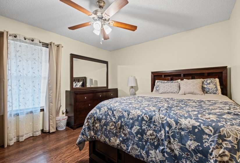 Spacious room featuring wood-finish flooring, a vaulted ceiling, and a ceiling fan with integrated lighting