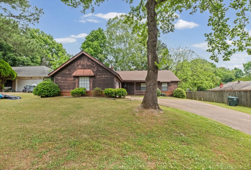 Ranch-style exterior featuring wood shake siding, a covered front porch, and a dormer window with a metal awning