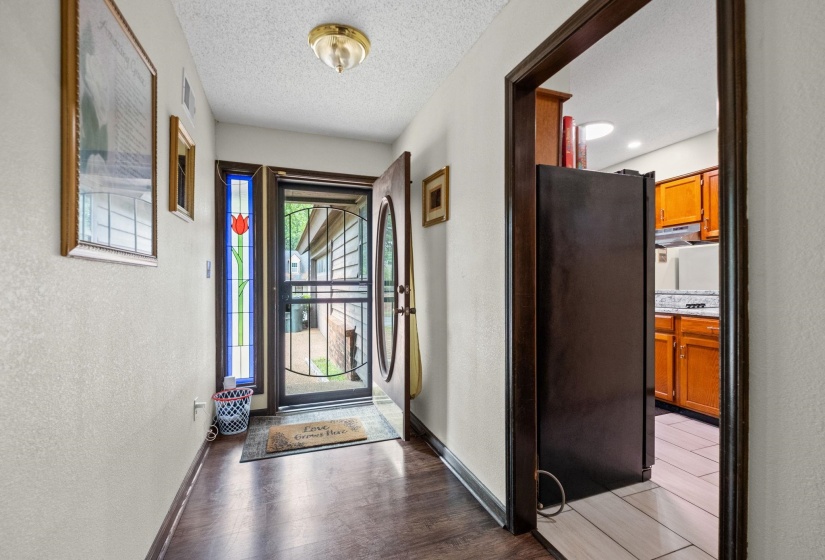 Entryway with wood-finish flooring and a decorative stained-glass sidelight