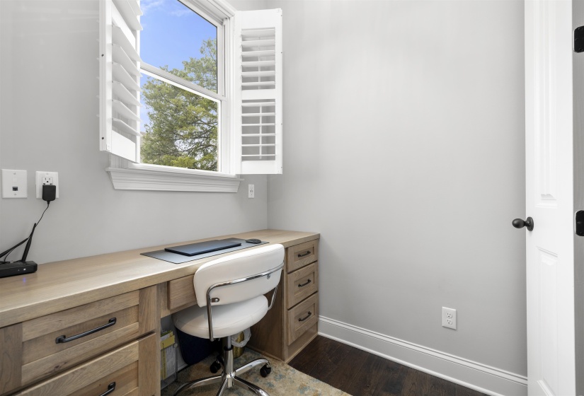 Built-in wood-finish desk with drawers and cabinet storage